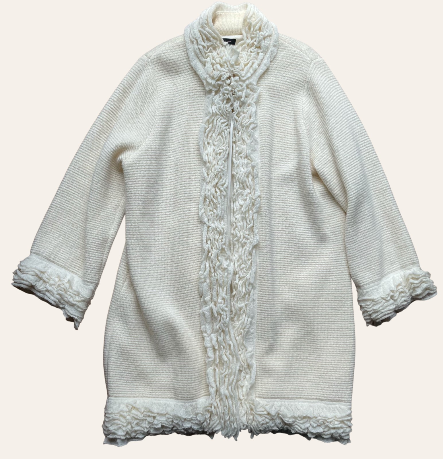 A vintage cream-colored jacket photographed flat, showing soft, worn texture