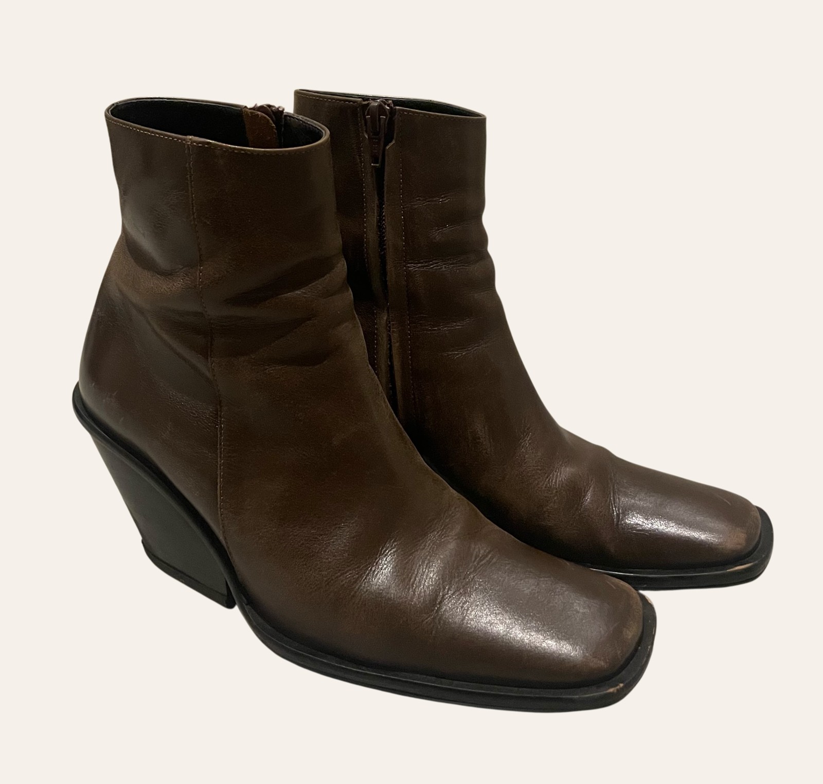 A pair of worn leather ankle boots photographed flat