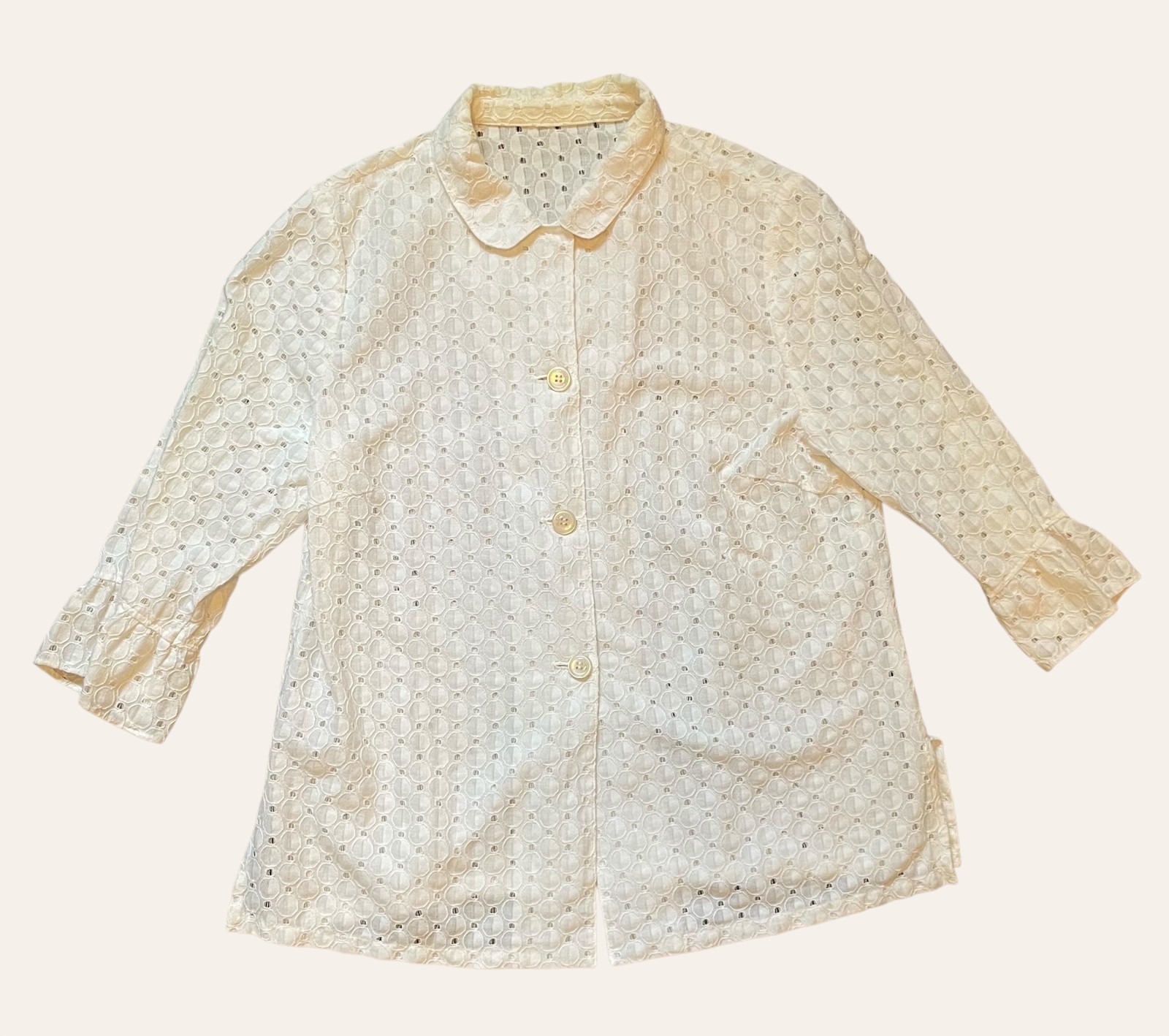 A cream, neutral-toned vintage blouse photographed flat