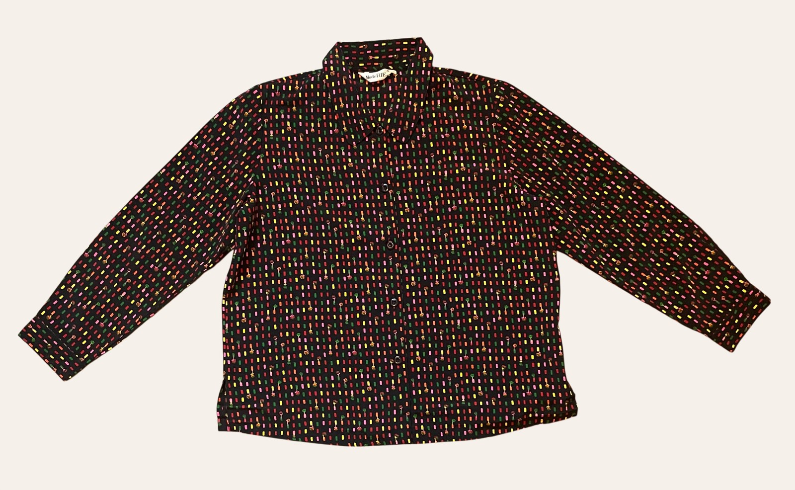 A vintage floral blouse photographed flat, showing visible texture and age