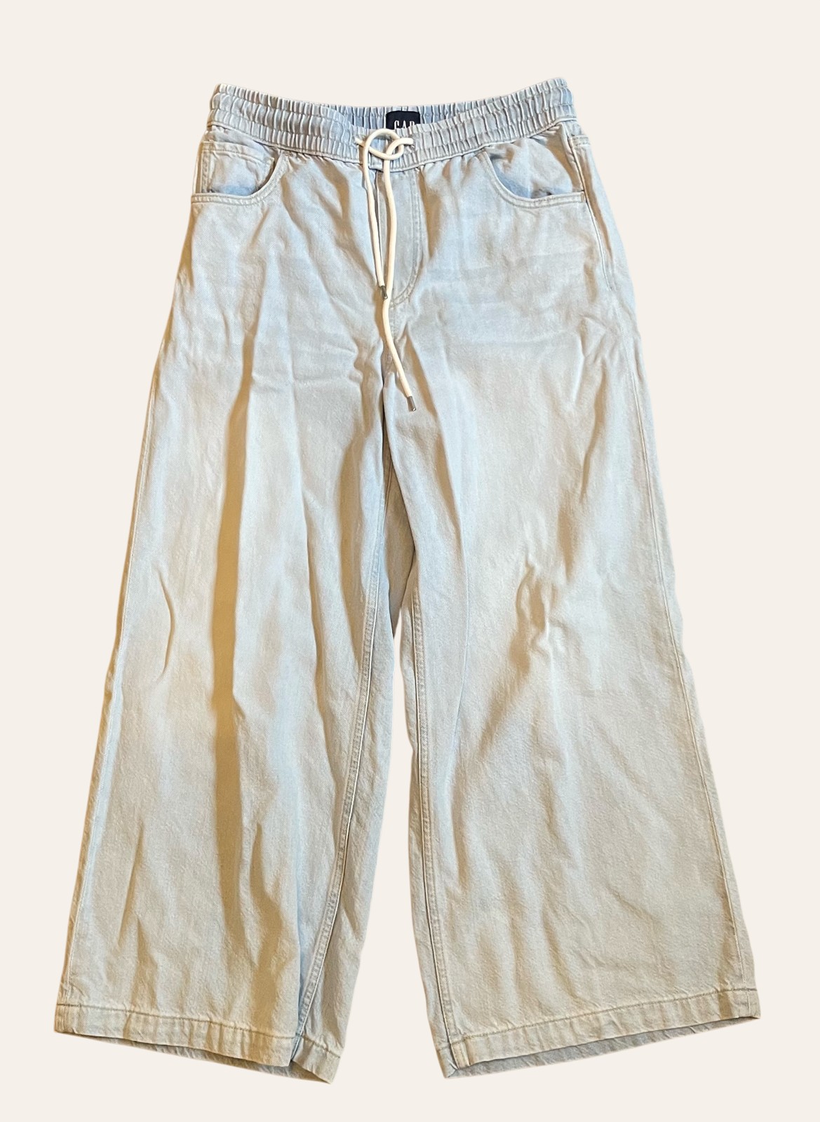 A pair of neutral wide-leg trousers photographed flat