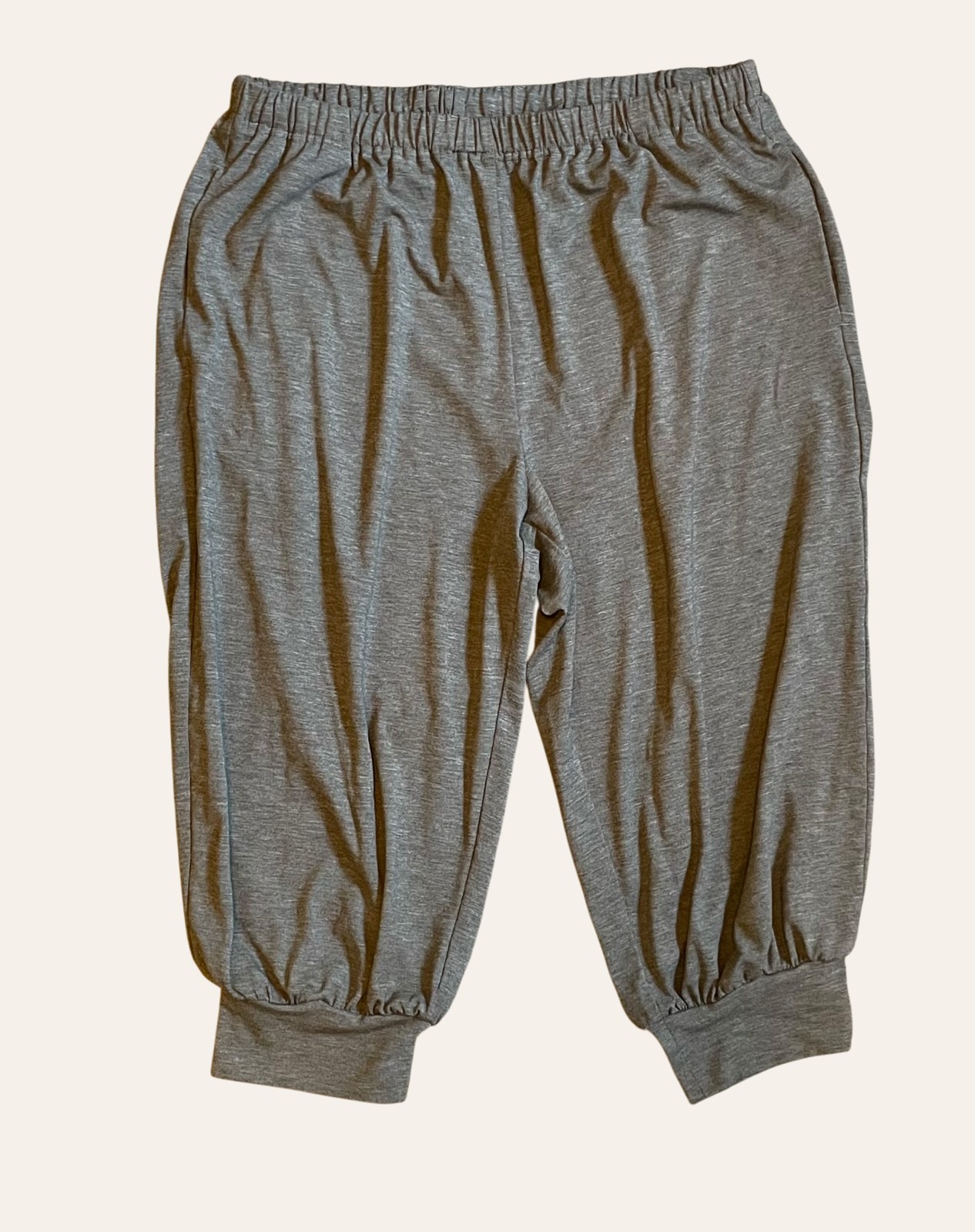 A pair of neutral grey relaxed trousers photographed flat
