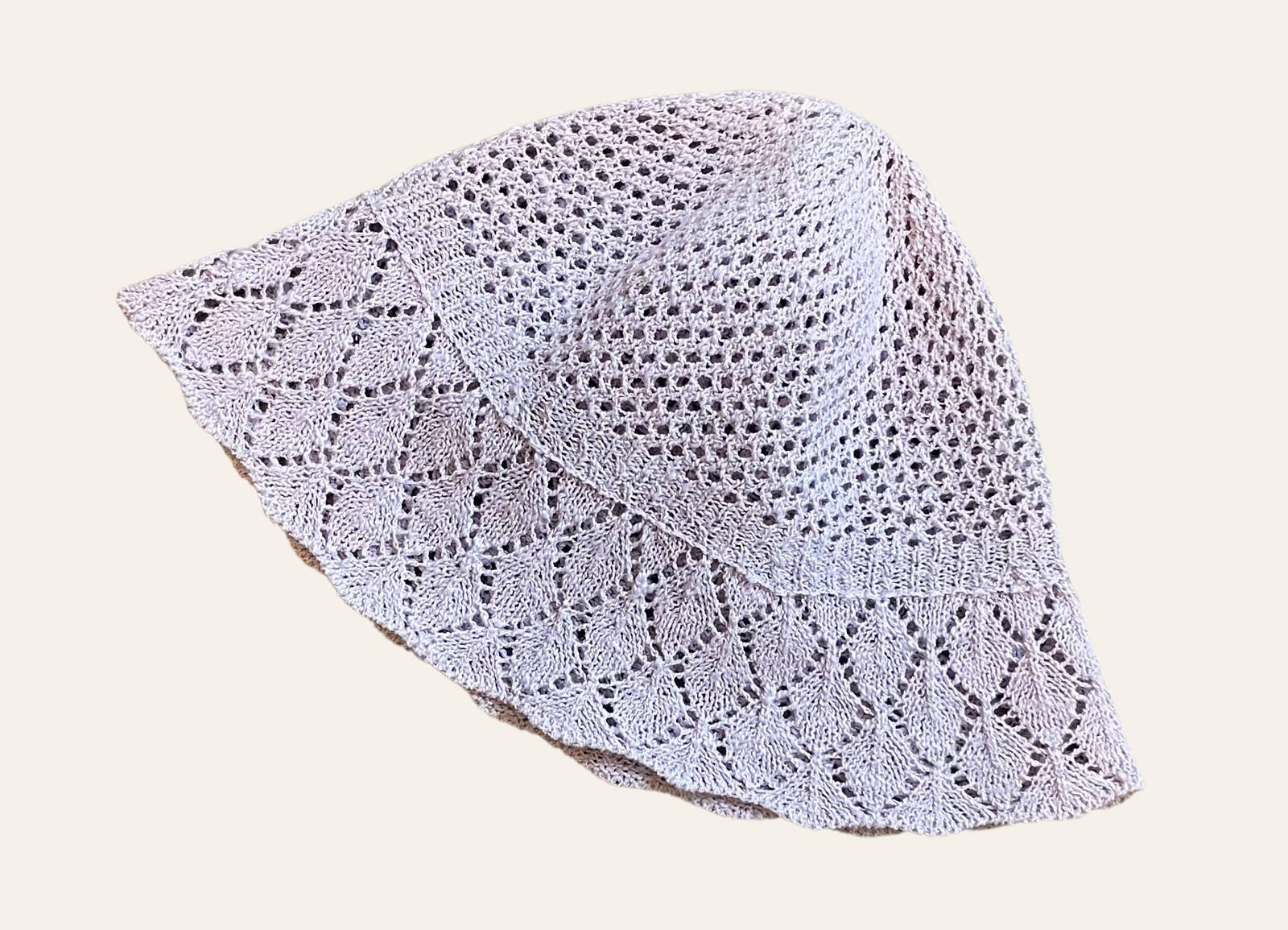 A soft cream secondhand knit accessory photographed flat